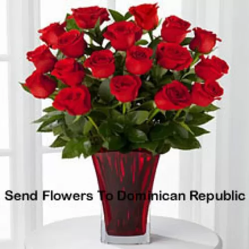18 Rosas Vermelhas com Enchedores Sazonais em um Vaso de Vidro Decorado com um Laço Rosa